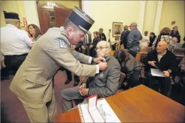  ?? AMY E. VOIGT / THE BLADE ?? French Colonel Nicolas Auboin (left) pins the French Legion of Honor medal onto Wyandot County resident and World War II veteran Clyde Shull during a ceremony at the Wyandot County Courthouse on Monday. Shull fought in North Africa, Italy, France and...