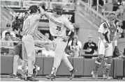  ?? [AP PHOTO] ?? Oregon State’s Adley Rutschman (35) is congratula­ted by Michael Gretler after his solo home run against Arkansas during the fourth inning in Game 2 of the College World Series finals Wednesday in Omaha, Neb.