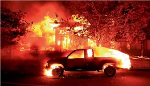  ?? AP ?? Coffey Park homes burn early on Monday in Santa Rosa, California. —