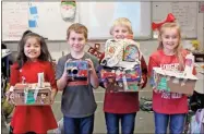  ?? Kelcey Caulder ?? First grade students GiGi Ortiz, Wyatt Pierce, Aden Davis and Payson King created cardboard gingerbrea­d houses and other inventions, like tanks, on STEM Day on Monday.