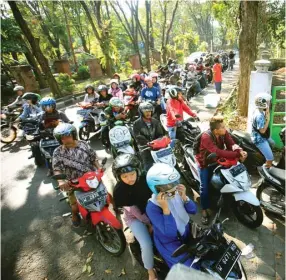  ?? DIMAS MAULANA/JAWA POS ?? MENGULAR: Foto bawah, petugas Arif Junofal membantu pelayanan di Samsat Drive Thru AlunAlun Sidoarjo kemarin. Ratusan warga mengantre menanti pelayanan hingga mencapai TL.