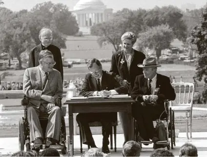  ?? Barry Thumma / Associated Press file photo ?? President George H.W. Bush signs the Americans with Disabiliti­es Act during a ceremony on the South Lawn of the White House on July 26, 1990. Some lawmakers believe the bill could not pass today in our divided nation.