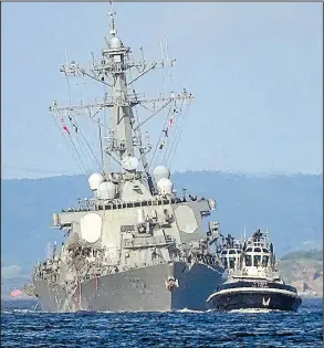  ?? AP/EUGENE HOSHIKO ?? The USS Fitzgerald is towed to its home port of Yokosuka Naval Base south of Tokyo on Saturday. The destroyer’s collision with a cargo ship caused flooding in berthing areas as most of its crew slept.