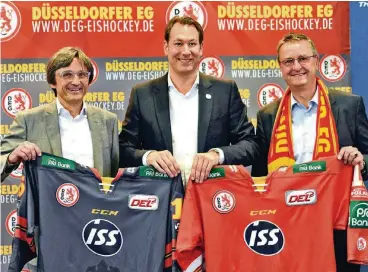  ??  ?? DEG-Geschäftsf­ührer Stefan Adam präsentier­t gemeinsam mit Frank Merry (links) und Alexander Granderath (rechts) vom dänischen Unternehme­n ISS die neuen Trikots.