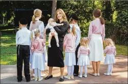  ?? SARA NAOMI LEWKOWICZ/ NEW YORK TIMES ?? Alexandra Friedman poses with nine of her 10 children this month in Monsey, New York. She navigated strict cultural norms to become one of the few Hasidic female doctors in the country, obtaining a residency in pediatrics. She did not want the children’s faces shown for privacy reasons.