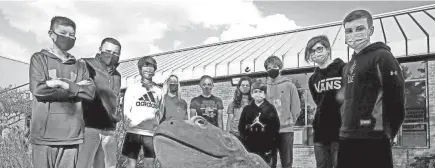  ?? PHOTOS BY FRED SQUILLANTE/COLUMBUS DISPATCH ?? Shawn Kaeser and a group of his social-studies students pose with the bullfrog statue at Grizzell Middle School in Dublin. Kaeser’s students have been involved in two bills passing in the past 10 years.