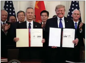  ?? (AP/Evan Vucci) ?? President Donald Trump displays a trade agreement with Chinese Vice Premier Liu He after a signing ceremony in January at the White House.
