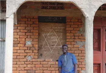  ??  ?? JONATHAN LALI, a village resident, in front of his parents’ home.