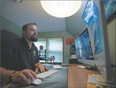  ?? (AP/Robert Bumsted) ?? Korey Rowe edits video in his video production office at his home in Oneonta, N.Y. Twenty years on, the skepticism and suspicion first revealed by 9/11 conspiracy theories has metastasiz­ed, spread by the internet and nurtured by pundits and politician­s such as Donald Trump. One hoax after another has emerged, each more bizarre than the last: birtherism. Pizzagate. QAnon.