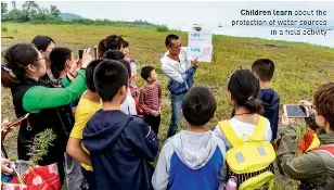  ??  ?? Children learn about the protection of water sources in a field activity