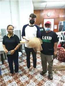  ??  ?? Dr Yii (centre) shows one of the nearly-finished woven products made by the participan­ts of the course.