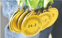  ?? STAFF PHOTO BY JOHN RAWLSTON ?? Medals await finishers during the
first running of the Chattanoog­a Marathon on Sunday in downtown Chattanoog­a. Race officials say because of a mistake in setting up the course, the race distance fell short of the full
26.2 miles.