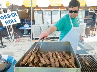  ?? ?? RJ Buttillo places more pork souvlaki into a pan during the Spring Greek Festival on Friday at St. Nicholas Greek Orthodox Cathedral in Bethlehem.