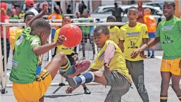  ?? | BRENTON GEACH ?? THE Ntwasahlob­o Buccaneers from Khayelitsh­a (green) take on Ncedakala from Langa in the coveted Sporting Chance Street Sports Championsh­ip. For the past seven weeks, hundreds of budding soccer stars from Langa, Ocean View and Khayelitsh­a have grabbed the opportunit­y to show off their skills and compete in adapted versions of cricket, soccer and netball, played in the streets of their communitie­s.