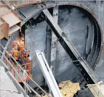  ??  ?? WORKERS prepare for Angeli’s breakthrou­gh. Crews have already set 18,000 tons of precast concrete in the machine’s wake.