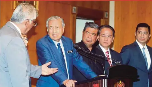  ?? PIC BY MOHD FADLI HAMZAH ?? Prime Minister Tun Dr Mahathir Mohamad speaking to Governance, Integrity and AntiCorrup­tion Centre director-general Tan Sri Abu Kassim Mohamed at the Special Cabinet Committee Meeting on Anti-Corruption in Putrajaya yesterday. With them are (from left) Defence Minister Mohamad Sabu, Minister in the Prime Minister’s Department Datuk Liew Vui Keong and Economic Affairs Minister Datuk Seri Azmin Ali.