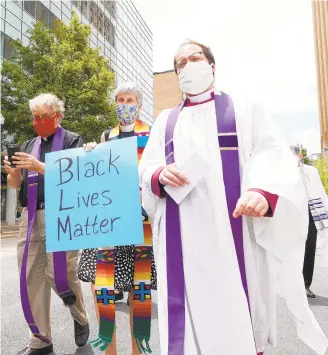 ?? DAVID GARRETT/SPECIAL TO THE MORNING CALL ?? White clergy from across the Lehigh Valley, led by the Rev. Dale Grandfield, right, of the Church of the Nativity in Bethlehem, march Thursday in Allentown to atone for their complicity in racism.