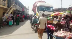  ?? A stranded truck opposite a one story building shops created on spaces surroundin­g the market ??