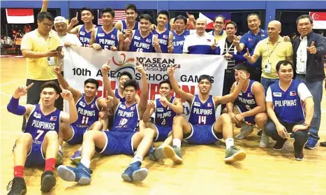  ?? PSC PHOTO ?? DOMINANCE. Players and coaching staff of the boys basketball team celebrate while flashing the number one sign after Team Philippine­s demolished Malaysia, 87-65, Wednesday to clinch the gold medal in the 10th Asean Schools Games. Also in photo are...
