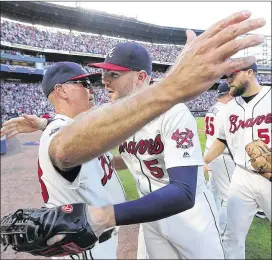  ?? CURTIS COMPTON / CCOMPTON@AJC.COM ?? Manager Brian Snitker and first baseman Freddie Freeman, the Braves veteran clubhouse leader, share an embrace after a victory last season. Freeman gave a whole-hearted endorsemen­t of the manager recently.