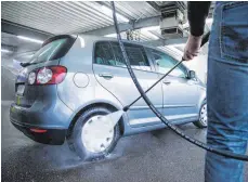  ?? FOTOS: DPA ?? Putzen mit Hochdruck: Aber bitte mit Vorsicht, denn ein zu geringer Abstand zum Auto kann Schäden verursache­n.