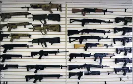  ?? ELAINE THOMPSON — THE ASSOCIATED PRESS FILE ?? Semi-automatic rifles fill a wall at a gun shop in Lynnwood, Wash.