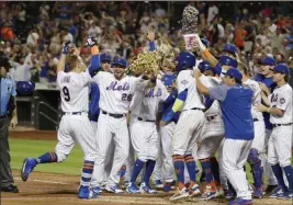  ?? Frank Franklin II ?? The Associated Press New York Mets outfielder Brandon Nimmo (9) runs toward home plate and waiting teammates after hitting a walk-off three-run home run in the 10th inning against the Philadelph­ia Phillies on Wednesday in New York.