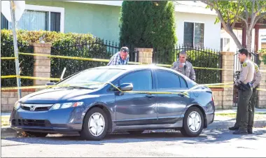  ?? Austin Dave/The Signal ?? Detective Bill Velek, left, with the Santa Clarita Valley Sheriff’s Station searches an older model Honda Civic Hybrid at the scene of a suspected fatal drug overdose near Spruce Street and 12th Street in Newhall.