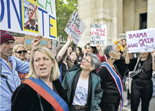  ?? AFP ?? Die Grüne Sandrine Rousseau (Mitte) mit Brille und kurzen grauen Haaren – hier bei einer Demo gegen sexuelle Gewalt gegen Frauen – tritt für die linke Wahlunion NUPES an.”