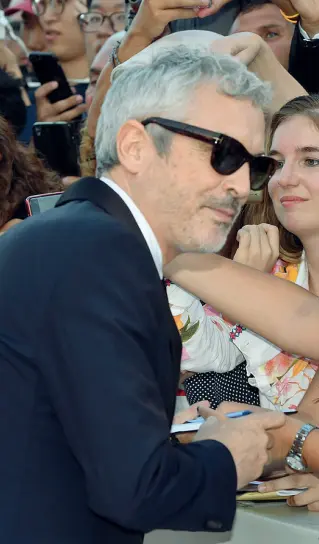  ??  ?? Leone Alfonso Cuarón, regista di «Roma» firma autografi sul red carpet (Pattaro/Vision)