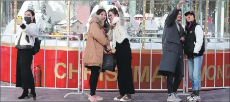  ?? WANG JING / CHINA DAILY ?? Young men and women dressed in fashion piece take selfies in Sanlitun, Beijing (2018).