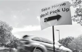  ?? Staff file photo ?? A sign points to the location at USAA’S headquarte­rs for the curbside meal and grocery pickup program for employees last year.