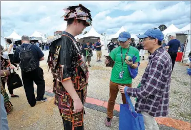  ?? NWA Democrat-Gazette/MICHAEL WOODS • @NWAMICHAEL­W ?? Brad Bloss with Perky Jerky, shares beef jerky samples Wednesday with Kobe Chen (center) and Wilson Zheng, Wal-Mart employees from China at the Wal-Mart Associate Expo at the Washington County Fairground­s. The expo gave Wal-Mart employees a chance to...