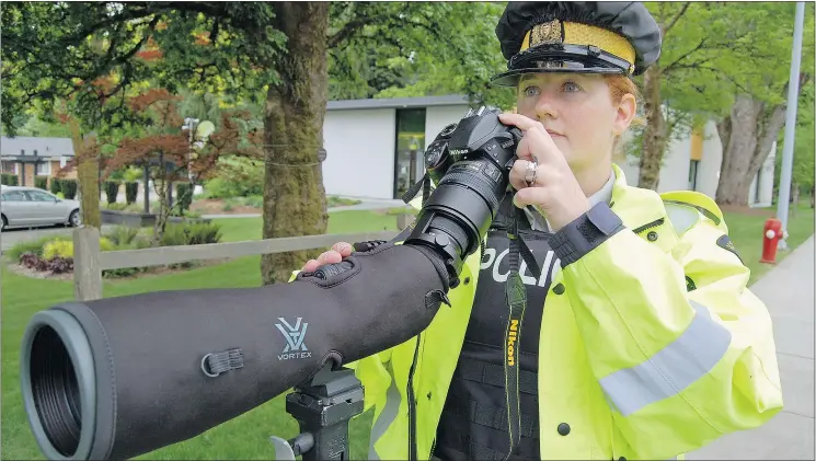  ??  ?? Const. Melissa Wutke of the RCMP looks for drivers texting in their cars on British Columbia roads with a camera and a long-range lens. — RCMP FILES