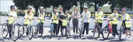  ?? (Photo: Katie Glavin) ?? Caroline Casey, Cork County Council Road and Water Safety Officer and teacher Ms Coughlan pictured with 4th class pupils Lily, Kornelia, Liubov, Nicole, Missy, Isabela, Eve, Maja and Melania at the Presentati­on Primary School, taking part in the Cycle Right Training Programme when The Avondhu visited.