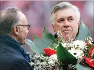  ?? ANDREAS GEBERT/AP ?? MILENIAL: Carlo Ancelotti menerima buket dari CEO Bayern Karl-Heinz Rummenigge di Allianz Arena sebagai simbol laga keseribu.