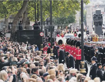  ?? ?? Crowds watch as the State Gun Carriage carries the coffin of Queen Elizabeth II,