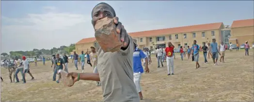  ?? PICTURE: MASIXOLE FENI. ?? PROTEST: A Cape Peninsula University of Technology student gets set to hurl rocks. Students are protesting against an increase in registrati­on, tuition and residence fees.