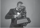  ?? KENT GIDLEY ?? Alabama wide receiver DeVonta Smith poses with the Heisman Trophy on Tuesday night.