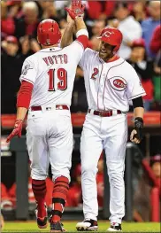  ?? JAMIE SABAU / GETTY IMAGES ?? Zack Cozart high-fives Joey Votto at home plate after Votto hit a two-run home run against the St. Louis Cardinals in June.