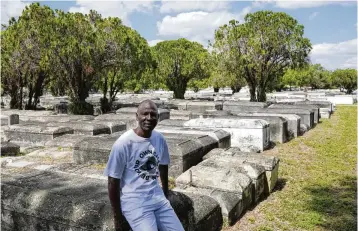  ?? MARTA LAVANDIER / ASSOCIATED PRESS ?? Jessie Wooden, owner of the Lincoln Memorial Park Cemetery in the Brownsvill­e neighborho­od of Miami, sits on a crypt on Feb. 26, 2024. Wooden bought the cemetery after finding out that his mother, who died when he was an infant, was buried there. “All my life I didn’t know her. All I knew was that mom was gone,” he said. “For me to be able to come where she’s resting at and be able to just to say a little prayer and talk to her, oh, that means so much to me.”