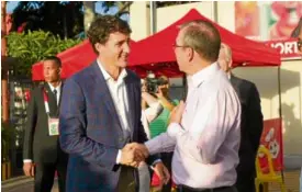  ??  ?? Jose Miñana, group president, Jollibee North America, welcomes the Canadian prime minister to the store.