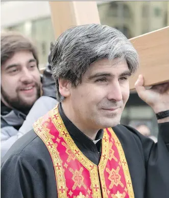  ?? PHOTOS: ELIZABETH CAMERON ?? Father Ephrem Kardouh, a monk who came here from Syria, was one of thousands of people to carry the cross through downtown Calgary on Good Friday.