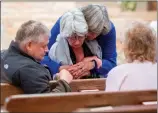  ??  ?? A grief counselor hugging a survivor