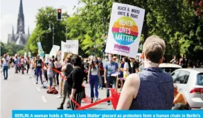  ??  ?? BERLIN: A woman holds a ‘Black Lives Matter’ placard as protesters form a human chain in Berlin’s Kreuzberg district, as they take part in a demonstrat­ion organised by the “#unteilbar” (indivisibl­e) movement. — AFP