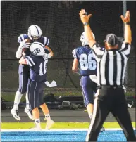  ?? Christian Abraham / Hearst Connecticu­t Media ?? Wilton’s Drew Phillips leaps in the end zone with teammate and brother Kyle Phillips after scoring a touchdown against Stamford on Oct. 28.