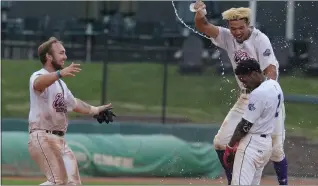  ?? KEN SWART — FOR MEDIANEWS GROUP ?? Tucker Rayburn, left, and Drue Galassi are the first to reach Utica Unicorns teammate Jon Hodo to celebrate his game-winning hit in the bottom of the 10th inning Sunday, which scored Isaac Phillips to give Utica a 6-5win over the Eastside Diamond Hoppers and clinch their third straight USPBL title.