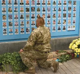  ?? ANATOLII STEPANOV/GETTY-AFP ?? A Ukrainian serviceman visits the Memory Wall of Fallen Defenders of Ukraine to mark Defenders Day of Ukraine on Sunday in Kyiv.