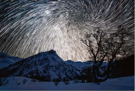  ?? Foto: Jonathan Besler ?? Der kreisende Tanz der Erdachse wird bei dieser eindrucksv­ollen Aufnahme durch 200 Einzelaufn­ahmen des Polarstern­s im Abstand einiger Minuten in einer kalten Winter nacht dargestell­t. Hier wird auch sichtbar, dass der Polarstern als Fixstern von allen Horizonten her die Orientieru­ng zeigt.