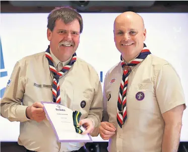  ?? ?? Honour Graeme is presented with his award by the current Chief Commission­er, Carl Hankinson